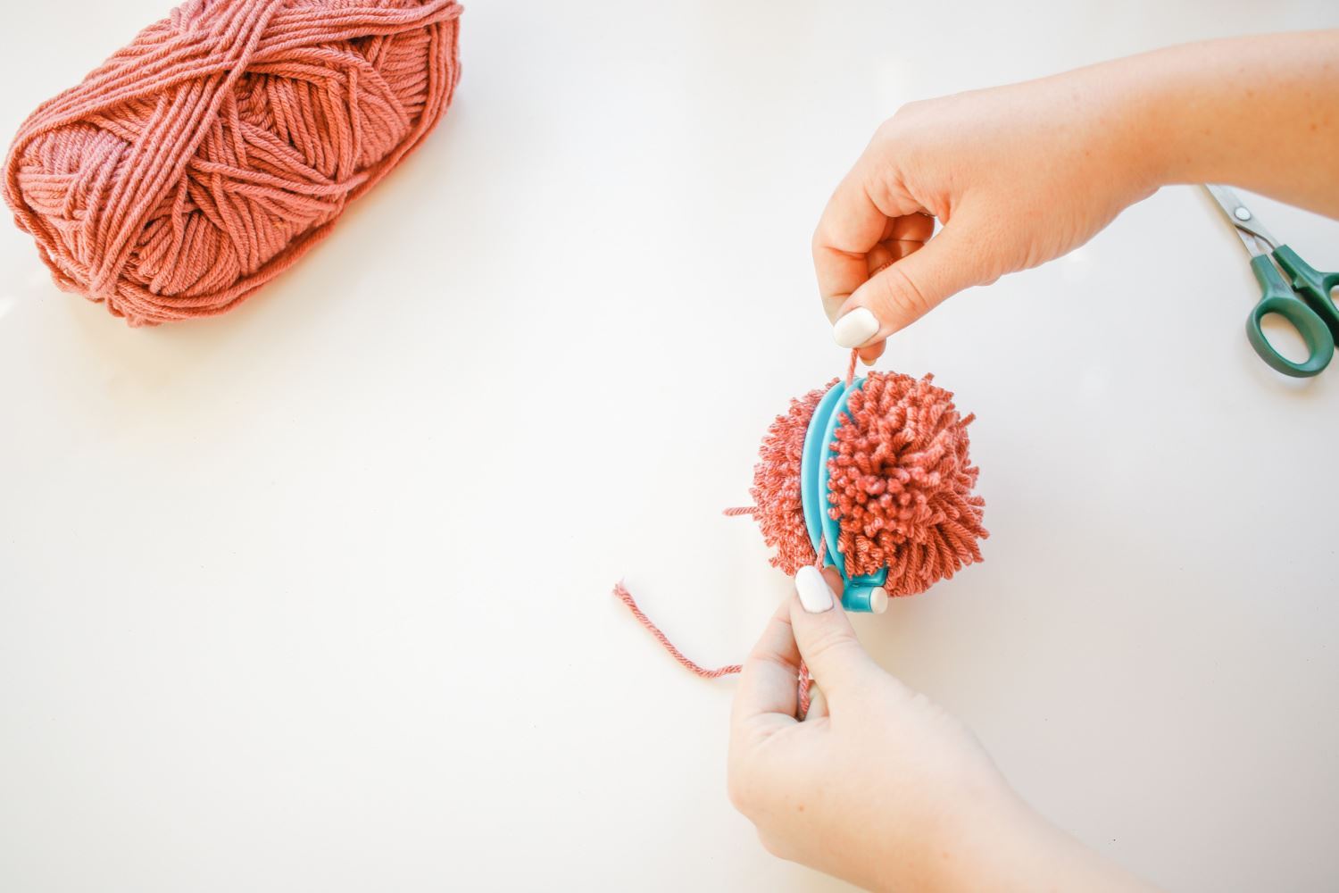 Tie a string around pompom